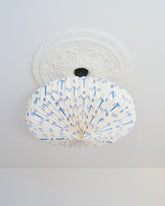 Decorative ceiling light fixture with blue and green design on a white ceiling