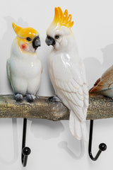 Zwei Keramikkakadus mit gelbem Kamm sitzen auf einem Vogelpärchen-Wandhaken in Form eines Astes und bringen Endless-Summer-Feeling und Farbe in jede bunte Garderobe.