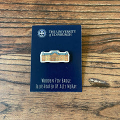 The Edinburgh College of Art wooden pin badge on its backing card.