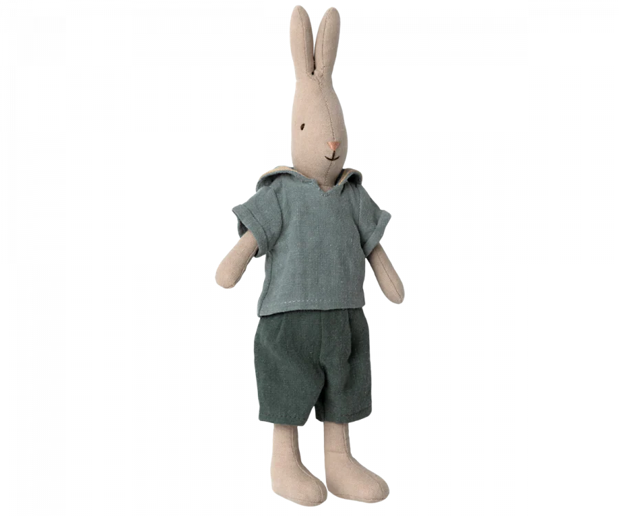 A Maileg Rabbit, Size 2 - Classic Shirt & Shorts, crafted from soft natural linen, wears a light blue shirt with a hood and dark green shorts. The rabbit stands upright with its long ears pointing up and has a simple, stitched facial expression. Perfect for any Maileg dollhouse collection.