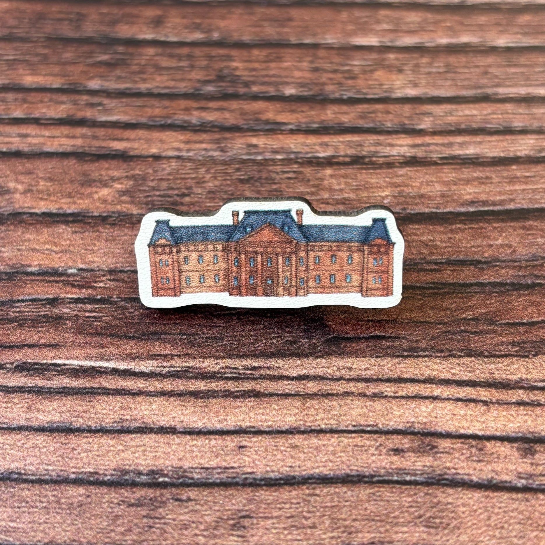 The Edinburgh College of Art wooden pin badge.